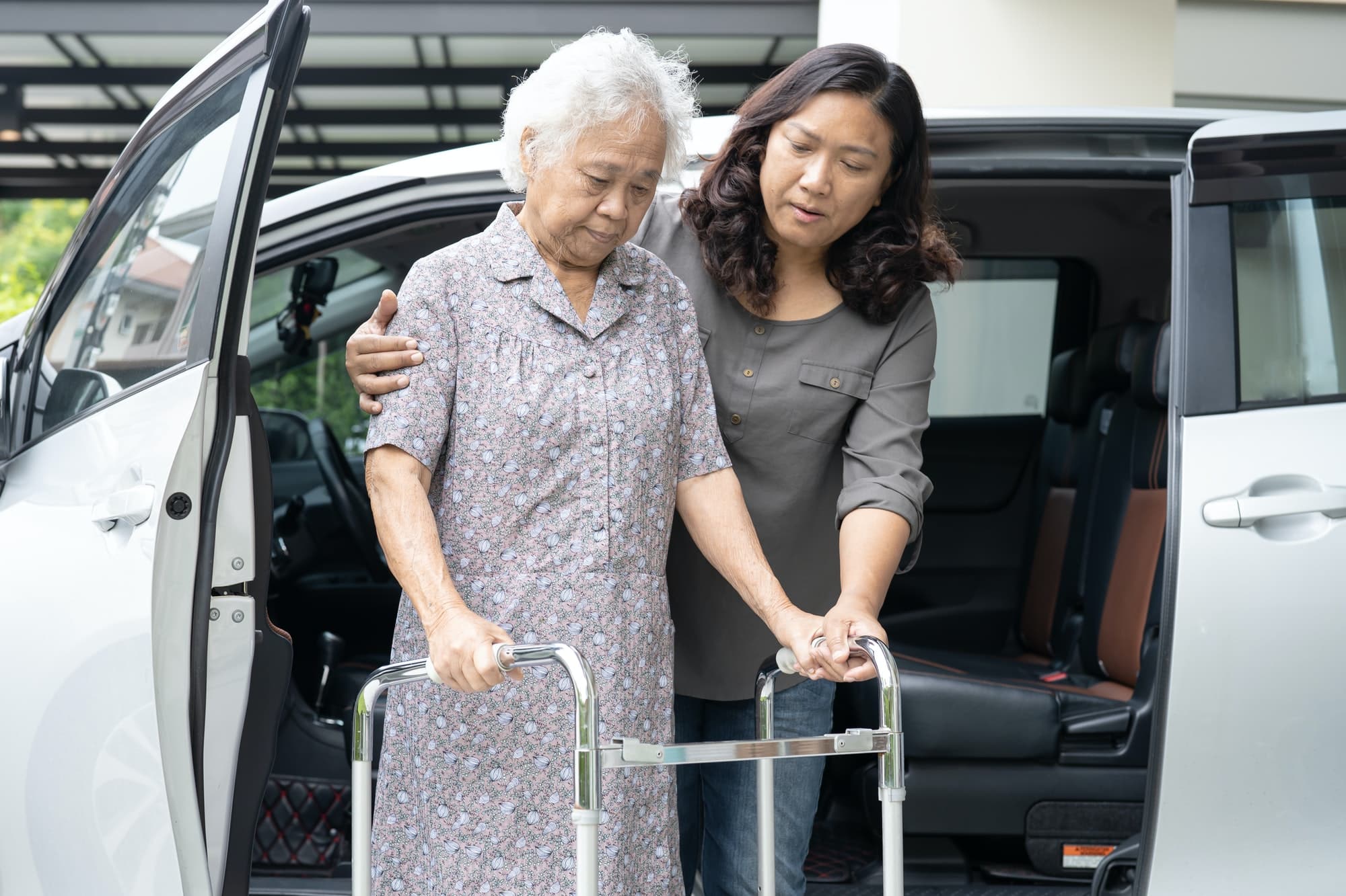Help and support asian senior woman patient walk with walker prepare get to her car